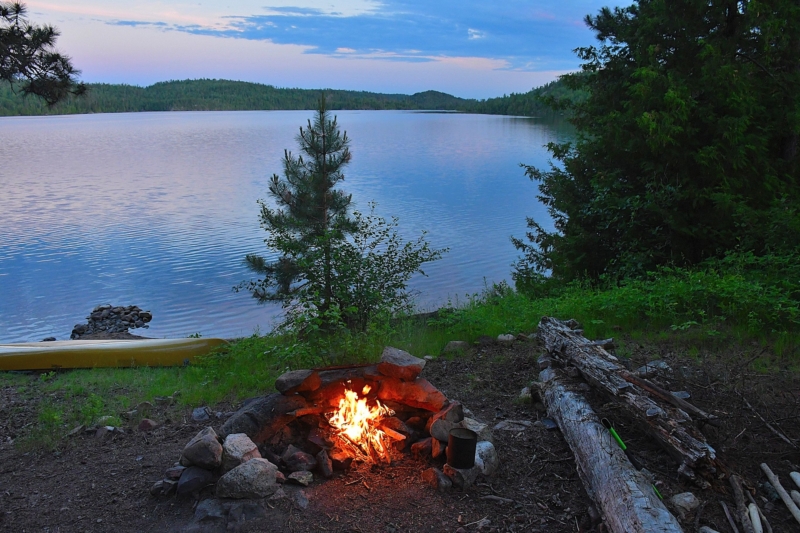 Campfire on the shore near a lake in the evening