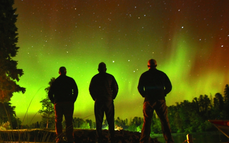 Outline of people standing and looking at the nothern lights
